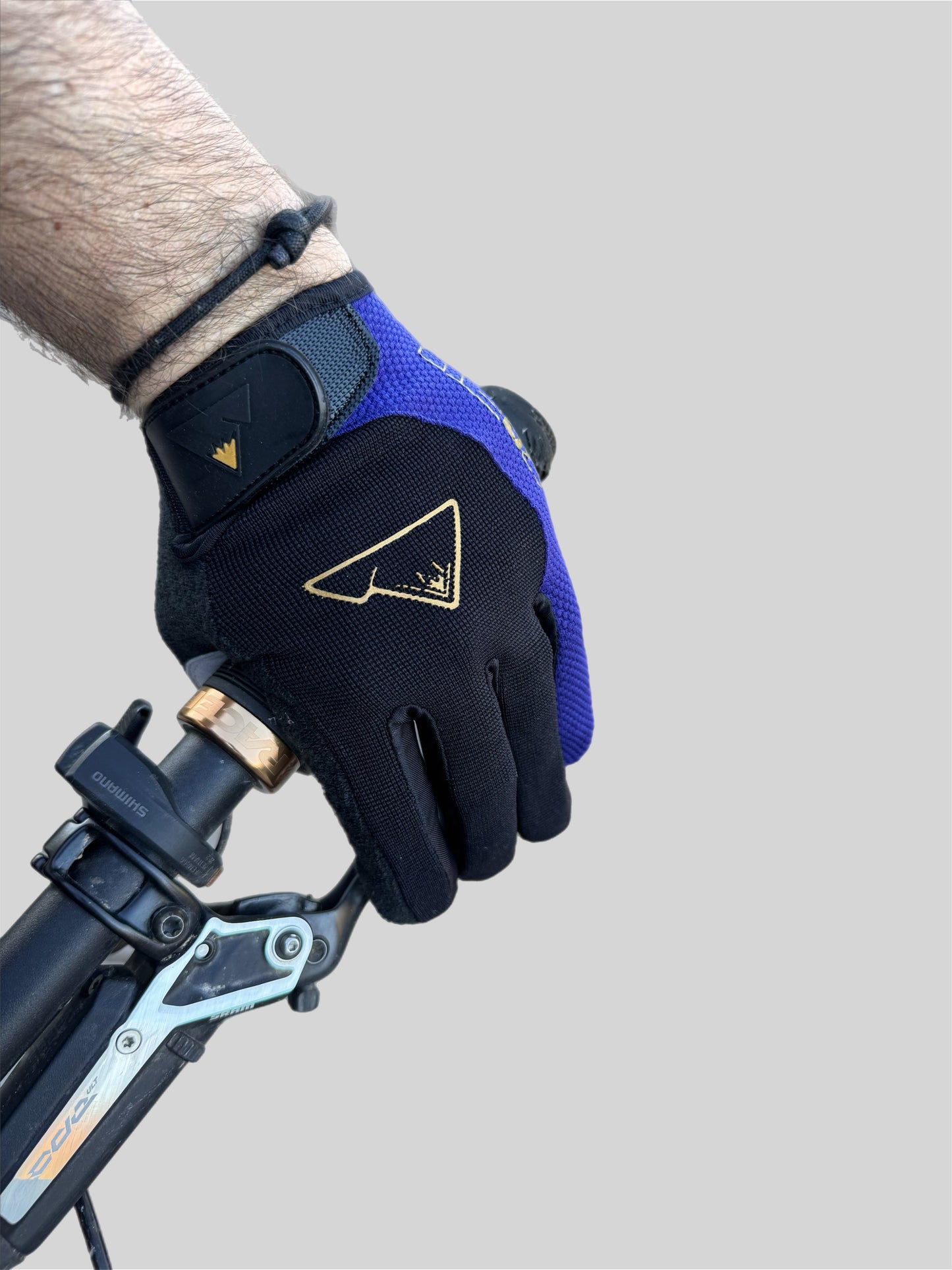 Close up of top of CROFTO padded MTB glove in Navy and black with gold logo