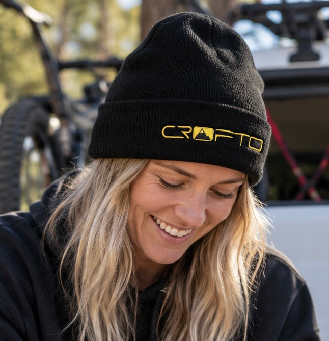 Female rider wearing a black and gold CROFTO beanie while relaxing after a mountain bike ride.