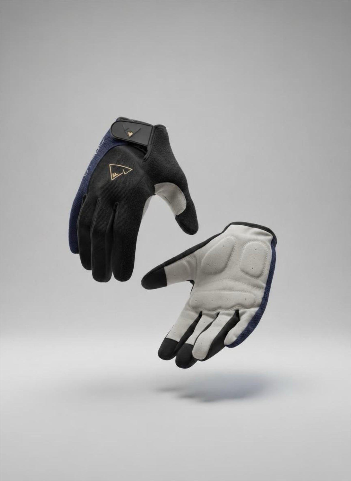 A pair of crofto padded MTB  gloves floating against a neutral gray studio background. One glove is shown palm-up in black with a small gold logo, and the other is shown palm-down in white with black and navy blue accents.