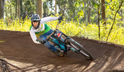 Boy riding a mountain bike in a berm wearing crofto jeans and Hacklberg MTB jersey