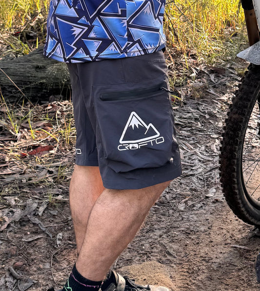 Close up of a mountain bike rider wearing navy crofto mtb shorts with white crofto logo