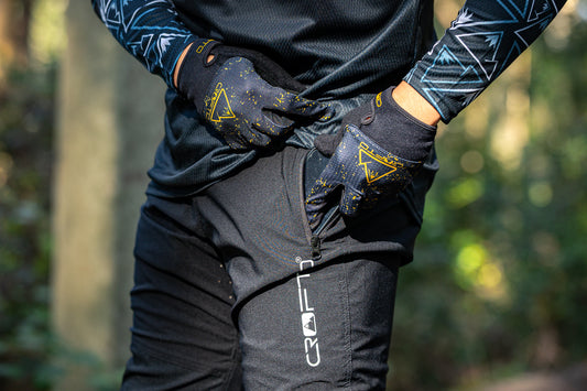 Close up of a person wearing crofto amaroo mountain bike pants putting a phone in the side pocket
