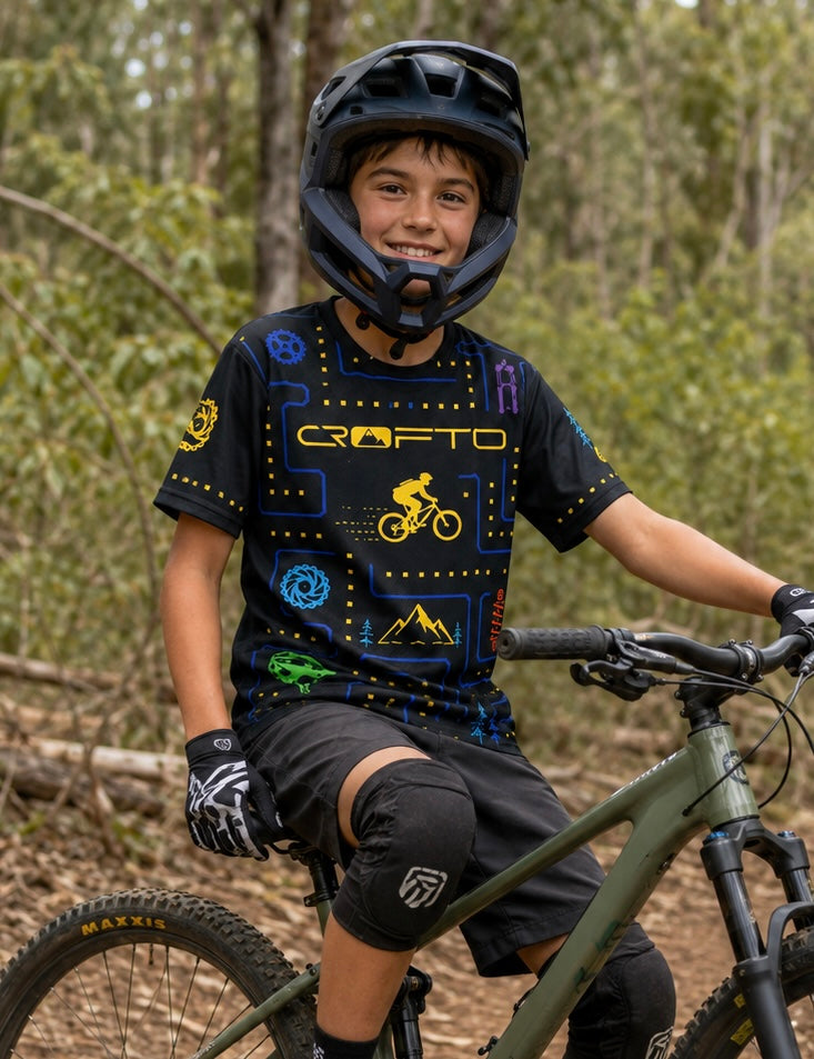 Boy sitting on a mountain bike wearing CROFTO trail maze mtb jersey.