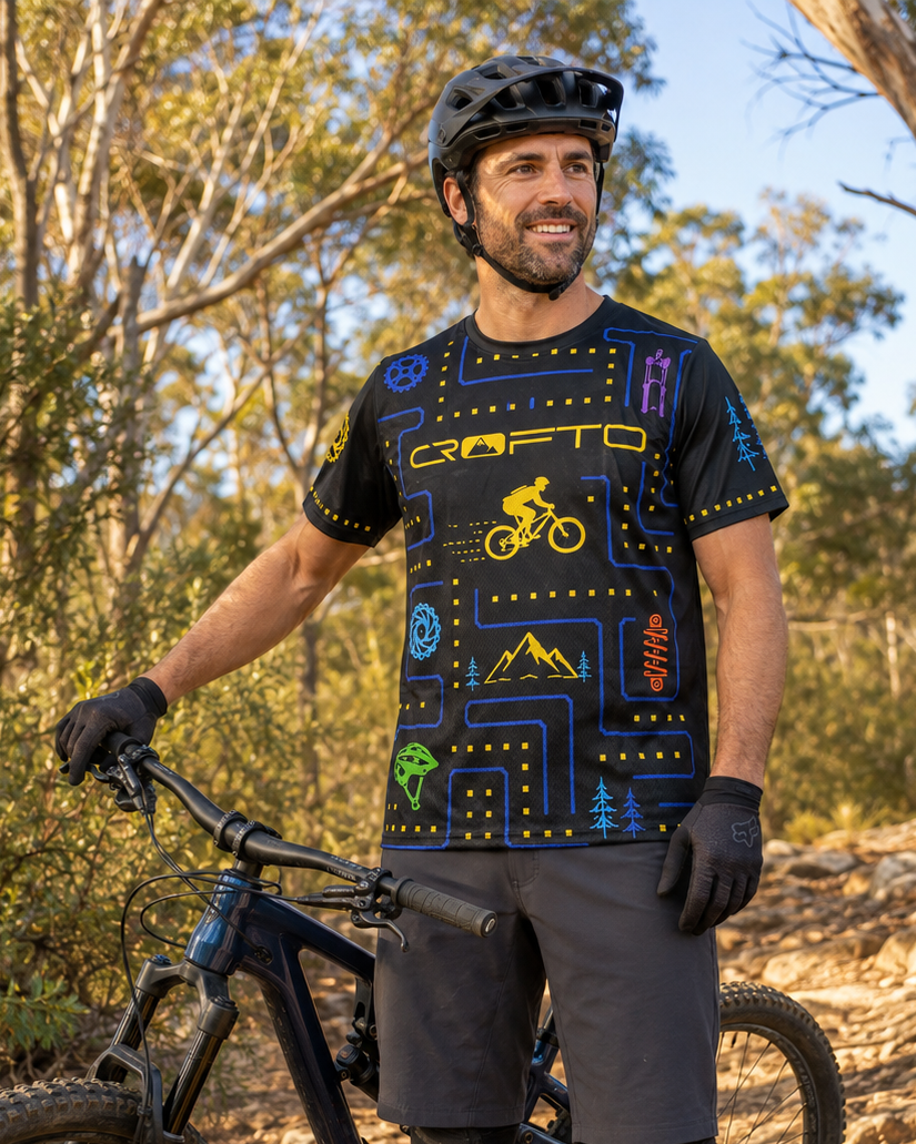 a man standing next to a mountain bike wearing a CROFTO trail maze MTB jersey