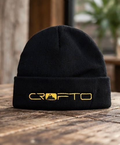 CROFTO Everyday Beanie in black with gold embroidered logo, featuring a classic fold-over cuff and knitted design.