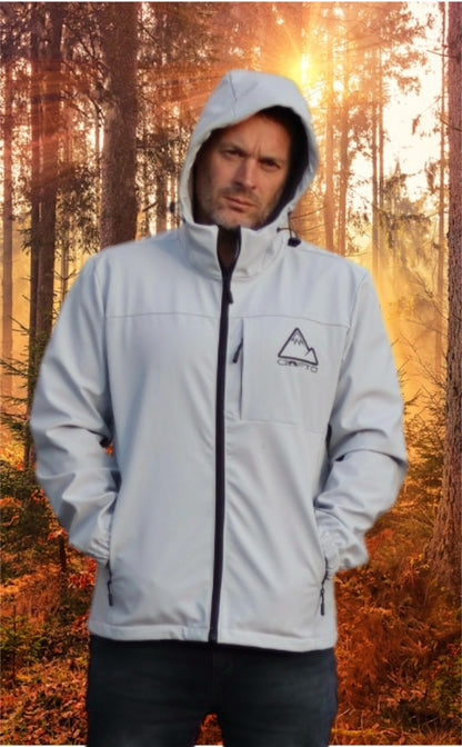 Man wearing a light gray crofto soft shell jacket in a forest during sunrise.