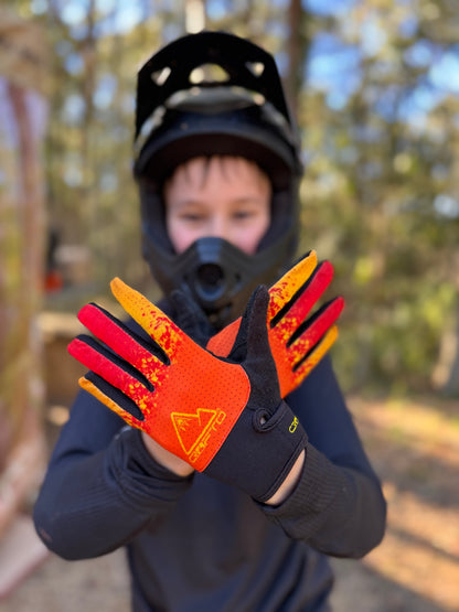 Child in a mountian bike park holds up his hands with crofto apex pro gloves on them