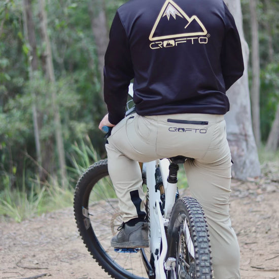 video of man riding a mountain bike on trails in forest wearing CROFTO amaroo MTB pants and black CROFTO jersey