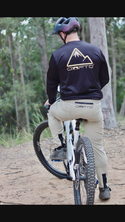 video of man riding a mountain bike on trails in forest wearing CROFTO amaroo MTB pants and black CROFTO jersey